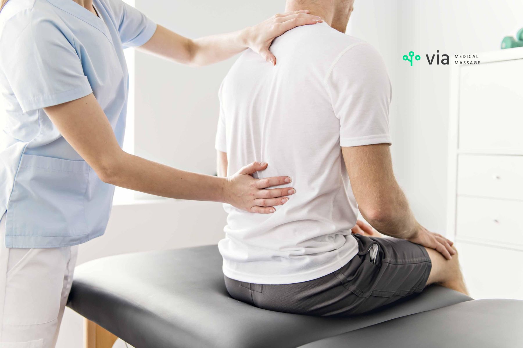 Doctor touching neck and back trying to find the cause of muscle or nerve pain