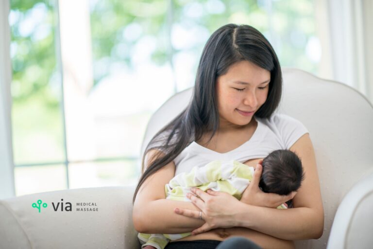 mother sitting in a chair in a bright room breastfeeding