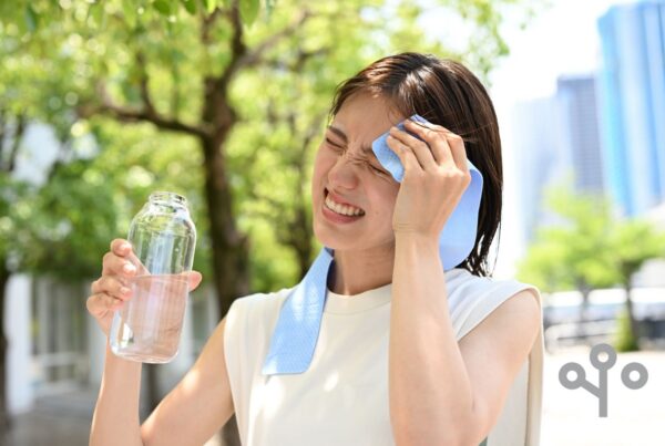 Woman wiping her brow in a heat wave holding water