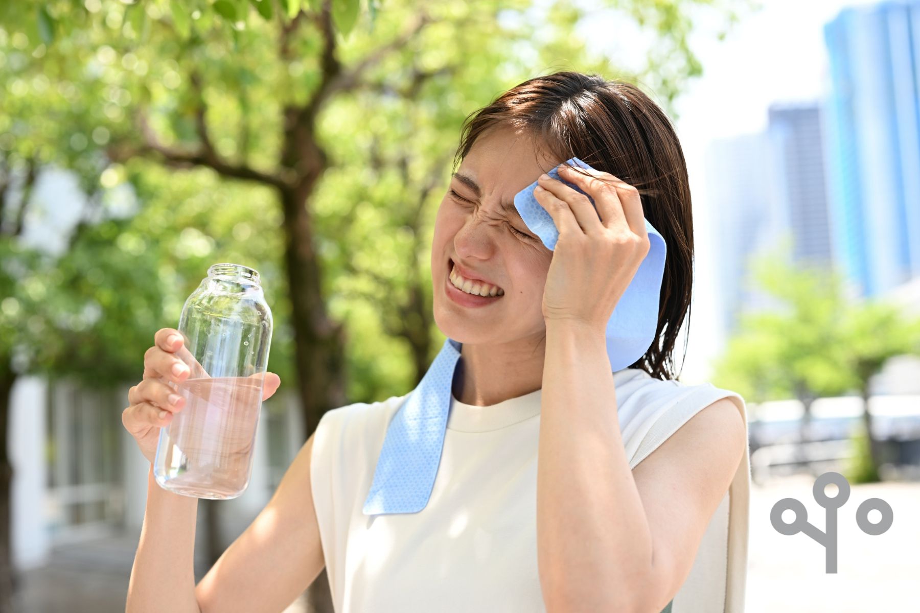 Woman wiping her brow in a heat wave holding water